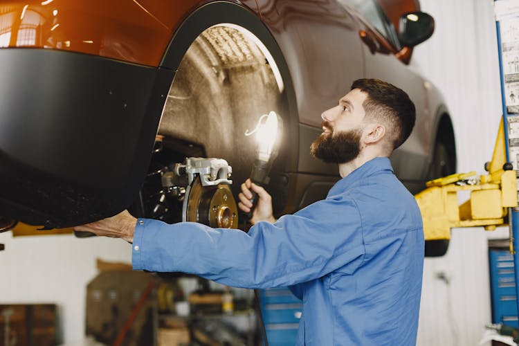 Man Checking On The Brakes Of A Vehicle