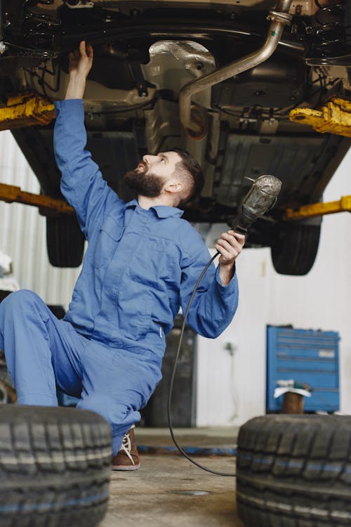 Free Man Working on the Brakes of a Car Stock Photo