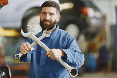 Man in Blue Dress Shirt Holding Steel Wrench