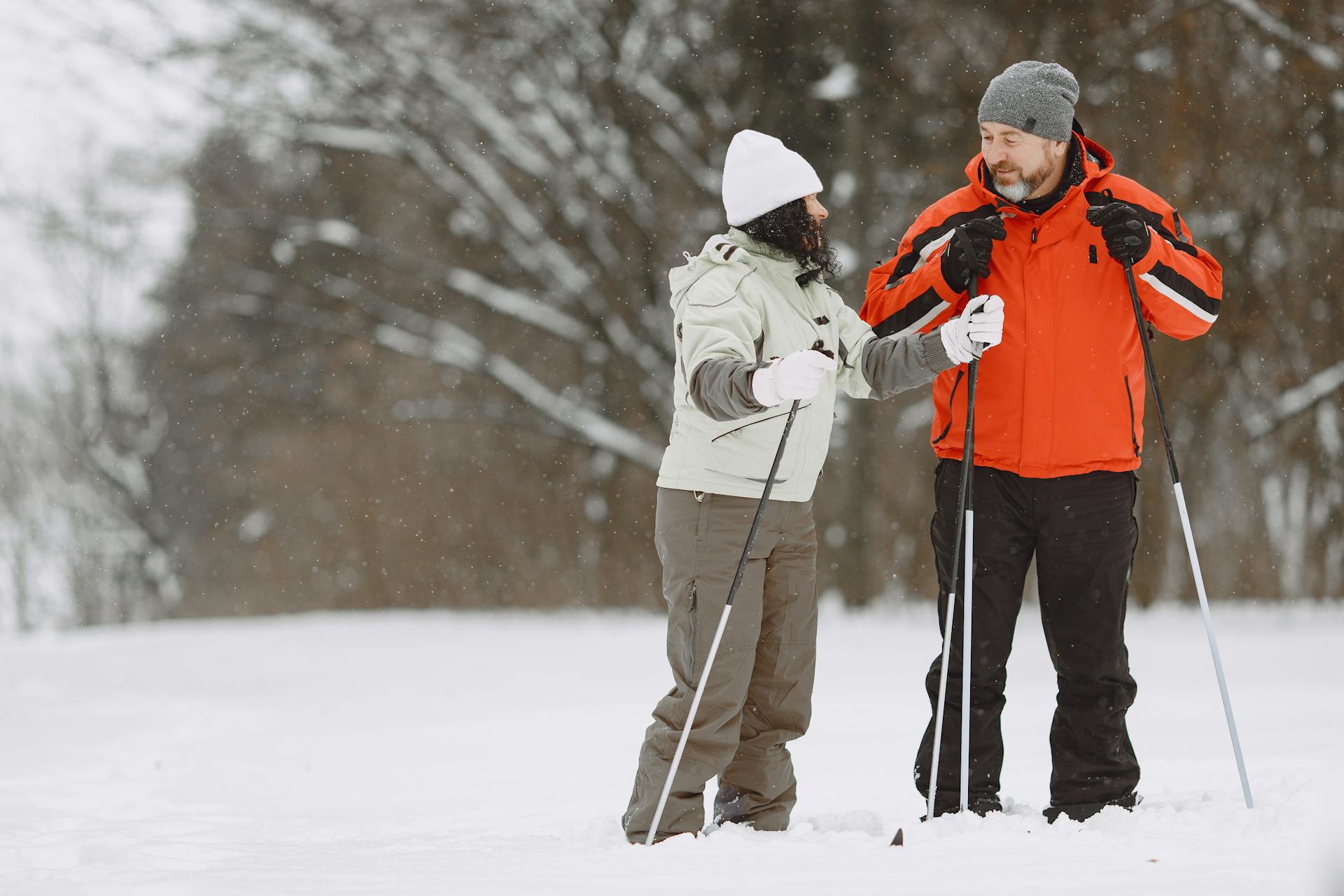 A couple skiing together in a snowy winter scene, enjoying the outdoors.