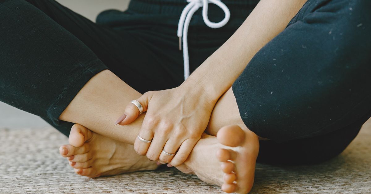 person sitting cross-legged on a yoga mat, hands resting on knees, soft focus on a peaceful face