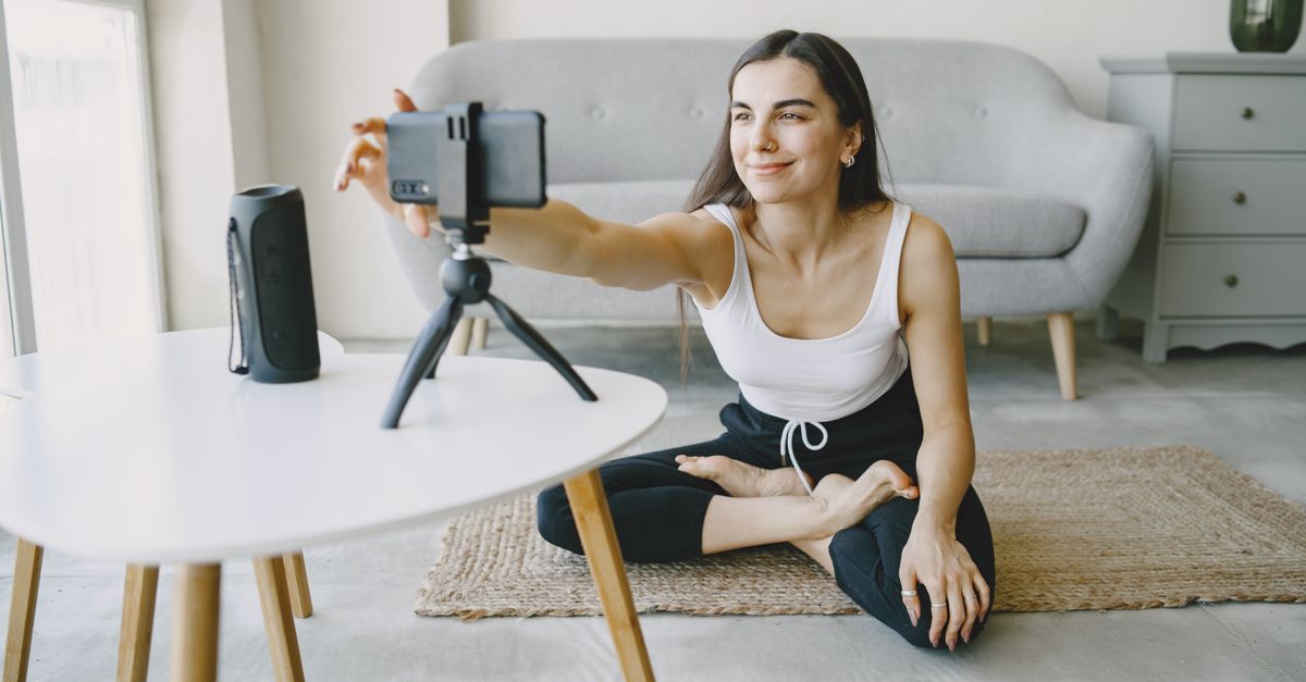 A creator films a vertical product video on a smartphone mounted to a tripod at home