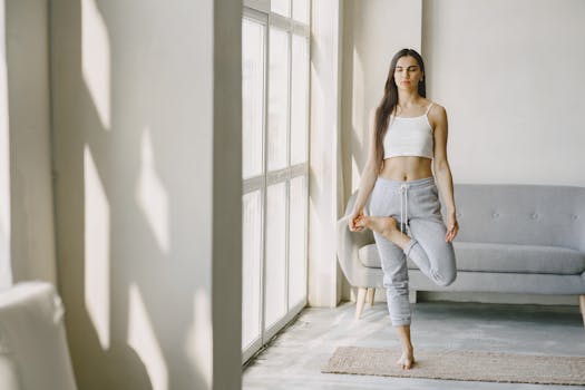 Woman practicing yoga indoors in a calm and serene setting, focusing on mindfulness and balance.