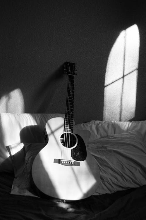 免費 灰色和白色紡織品上的白色原聲吉他 圖庫相片