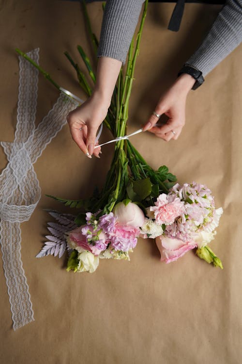 Free Florist tying bouquet of lush flowers in workshop Stock Photo
