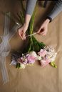Florist tying bouquet of lush flowers in workshop