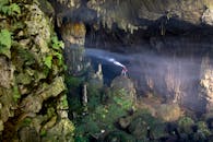 A Man Standing on a Rock in a Cave