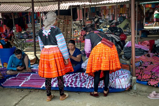 Vibrant scene of a traditional market with women in colorful traditional attire browsing textiles.