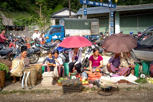 A vibrant rural market with local vendors selling fresh produce and goods under umbrellas.