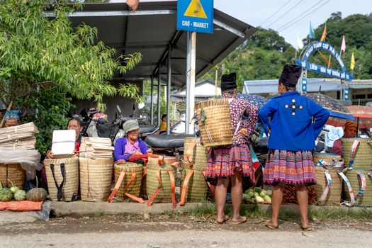 Vibrant local market with women selling handmade woven baskets and fresh produce.