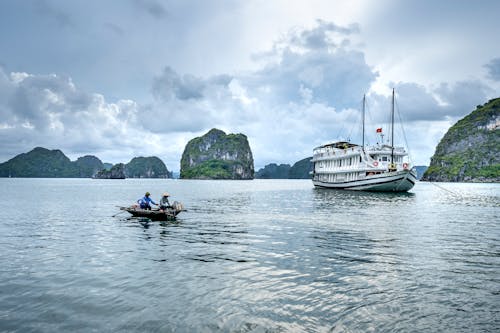 Ship and Canoe Sailing in Water 