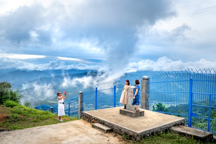 People Taking Pictures On Mountain Peak