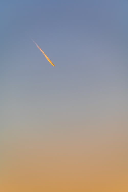 Low angle of single sphere with falling comet in cloudless gradient bright sky in evening