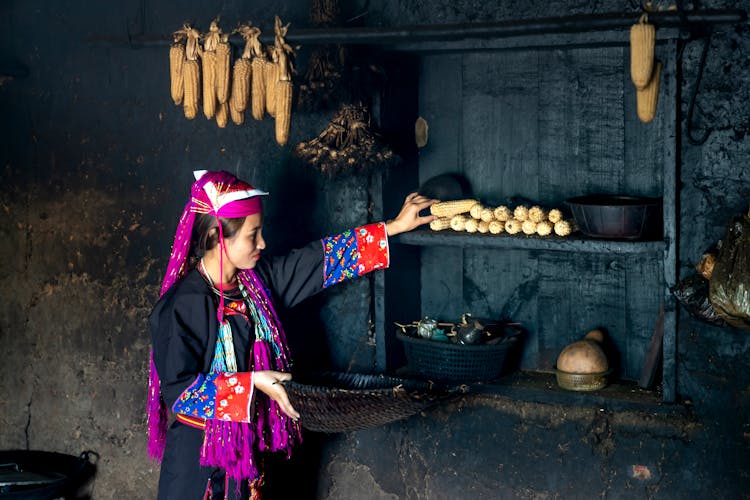 Woman In Traditional Clothes With Food At Home
