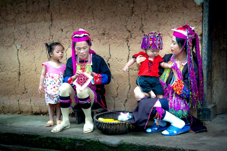 Vietnamese Women And Kids Sitting In Front Of A House 