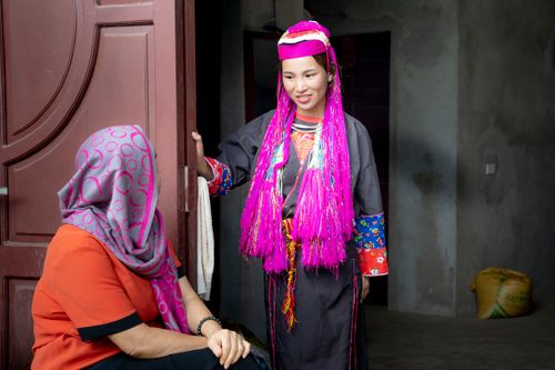 Free Two women engaging in cultural exchange at a doorway, showcasing traditional attire. Stock Photo