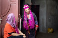 Women in Traditional Headscarves and Dresses Next to the Front Door