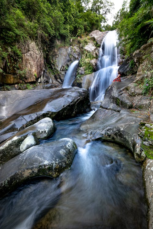 A Person Sitting near the Waterfall