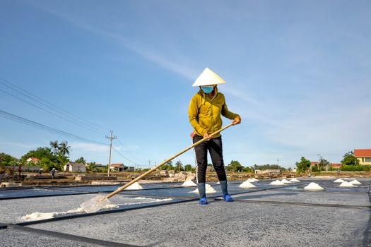 Man Spreading Salt with a Shovel as a Part of Salt Evaporation Process