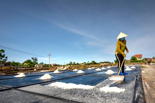 Man Spreading Salt with a Shovel as a Part of Salt Evaporation Process