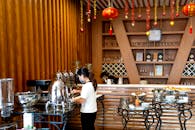 Woman Pouring Coffee from a Thermos in an Elegant Buffet