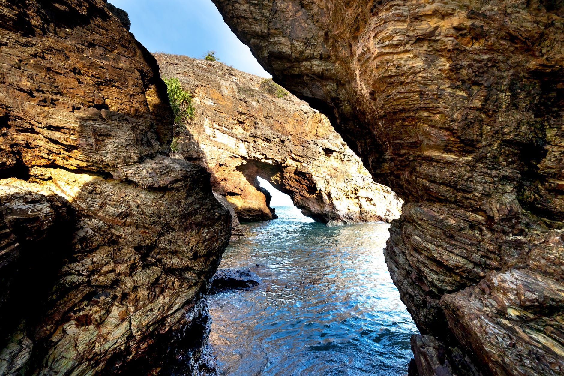 15 Texas State Parks That Feel Like Big Bend Without the 6-Hour Drive 11 A stunning natural rock arch over clear seawater in a coastal landscape.