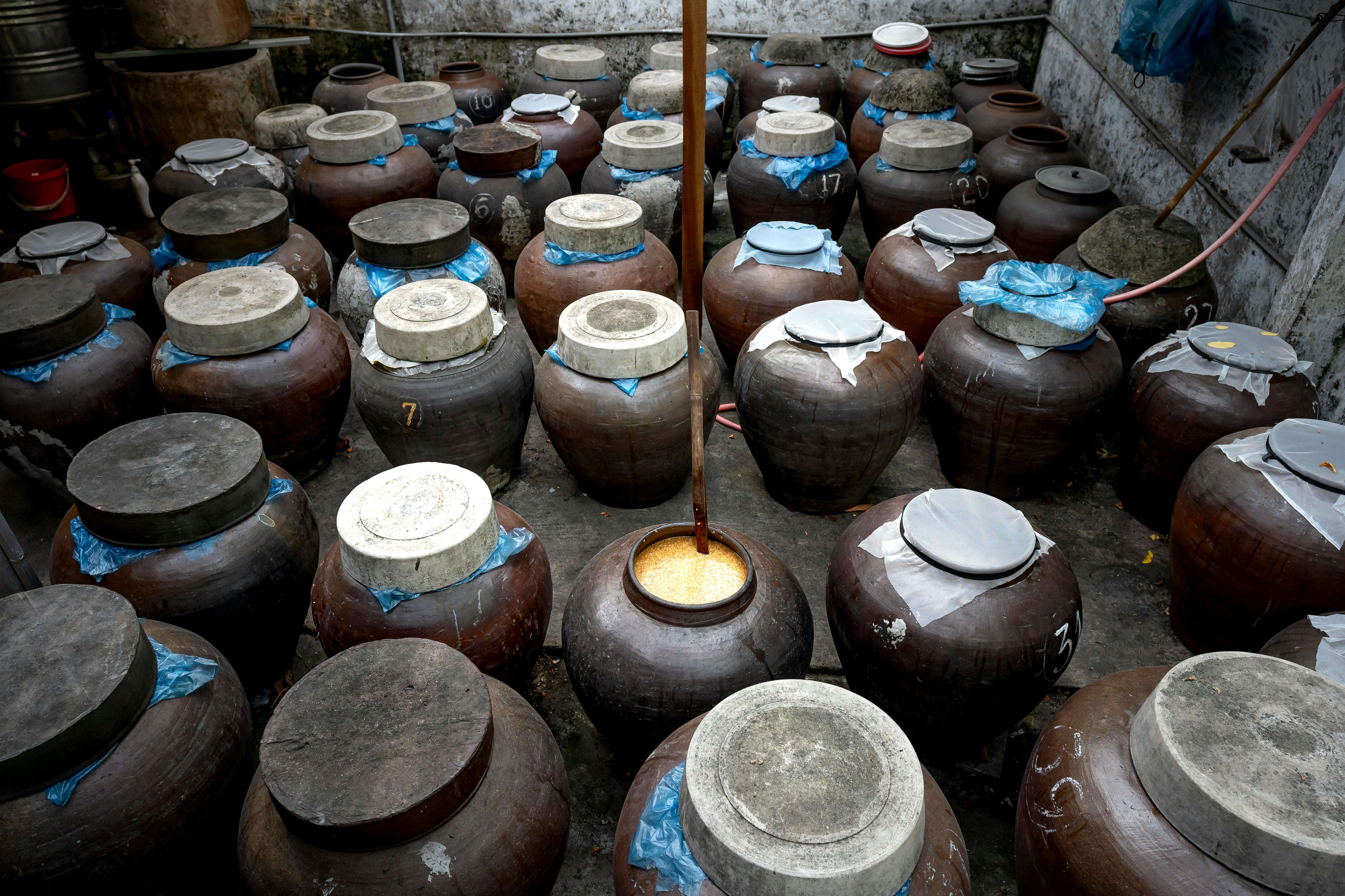 A collection of rustic ceramic jars in a traditional storage setting, showcasing cultural heritage.