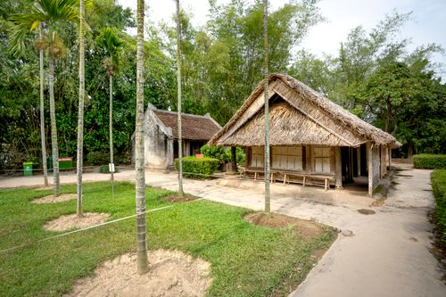 Free Scenic view of traditional wooden houses with straw roofs in a tropical setting. Ideal for travel and nature themes. Stock Photo
