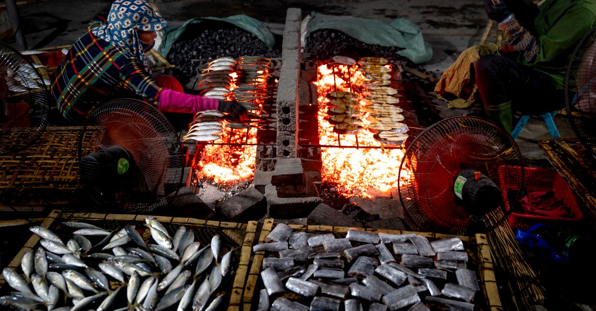 A bustling night market in Bali with colorful food stalls and locals cooking over charcoal grills