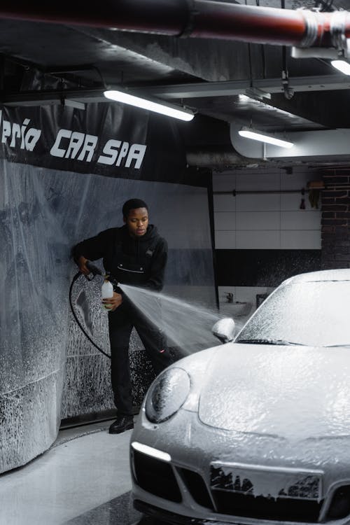 A Man in Black Hoodie Cleaning the Car