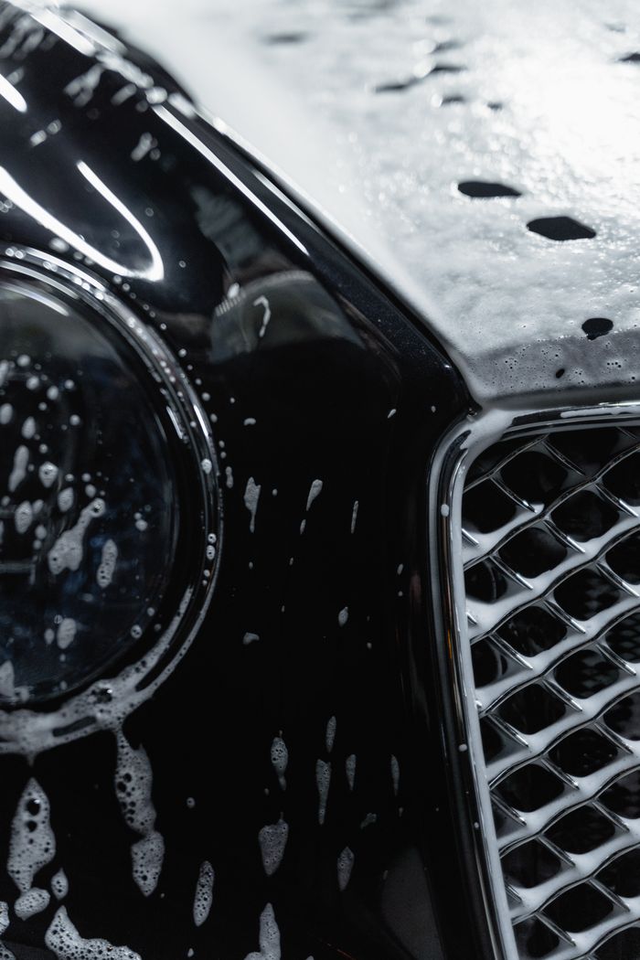 Soap suds on a black car's grille
