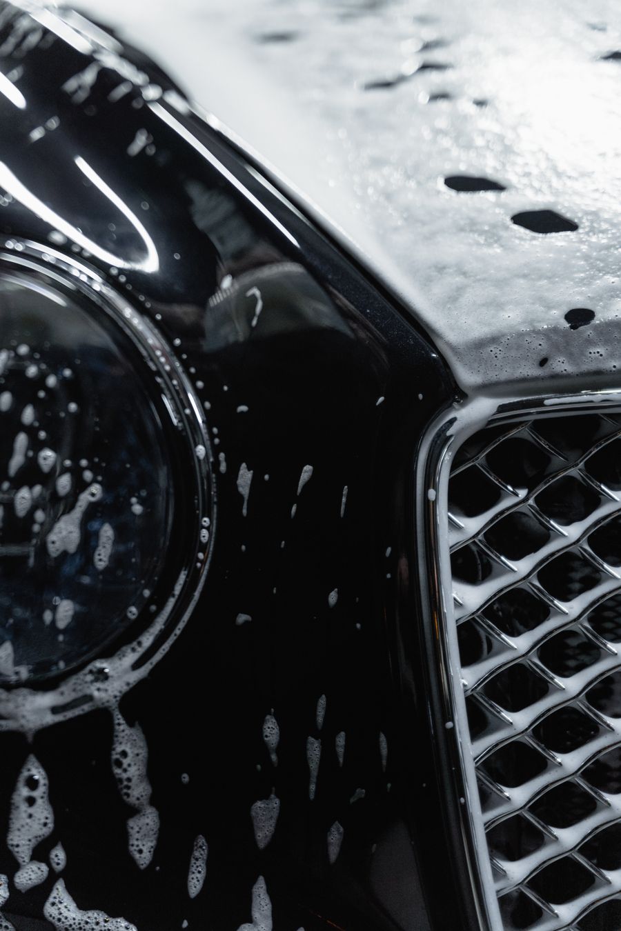Luxury car covered with soap suds during wash