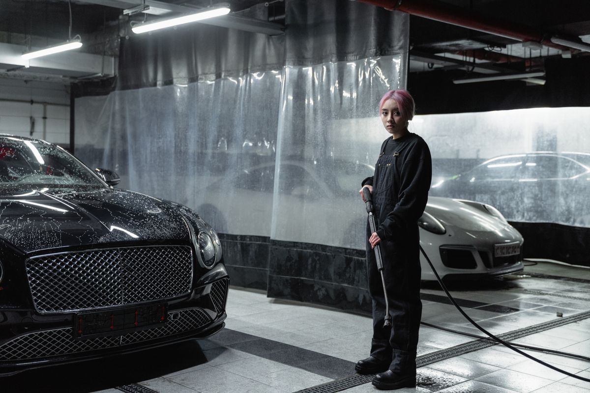 Vehicle receiving professional exterior detailing in a wash bay