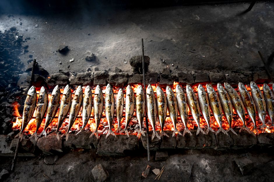 Grilled sardines over a smoky grill, a taste of Portugal's coastal delights.