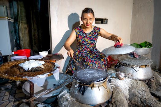 Woman crafting rice paper in a traditional Vietnamese setting, showcasing cultural culinary skills.