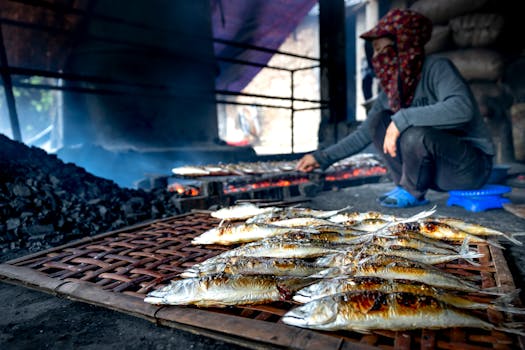 Woman grilling fish using traditional methods in a rustic setting with smoky ambience.