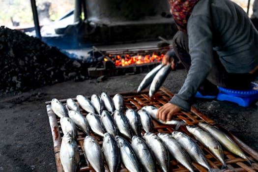 Fresh fish being grilled over charcoal at a vibrant Vietnamese market.