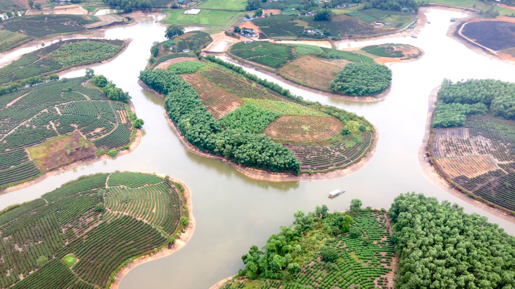 Beautiful aerial photograph showcasing lush green agricultural islands surrounded by serene waterways.