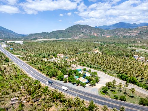 Free An expansive aerial view of a tropical countryside landscape with a highway cutting through lush greenery. Stock Photo