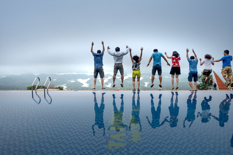 People Jumping By The Pool Side