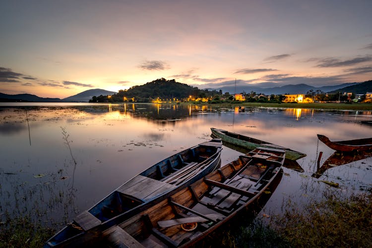 Boats Docked By Lake Shore At Night