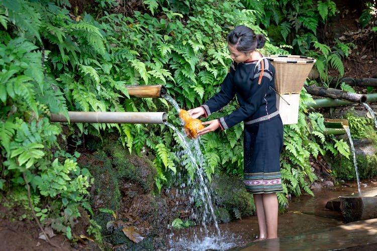 Woman Taking Rain Water In Forest