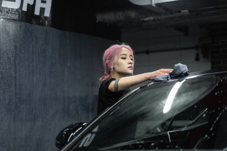 A Woman Cleaning A Car