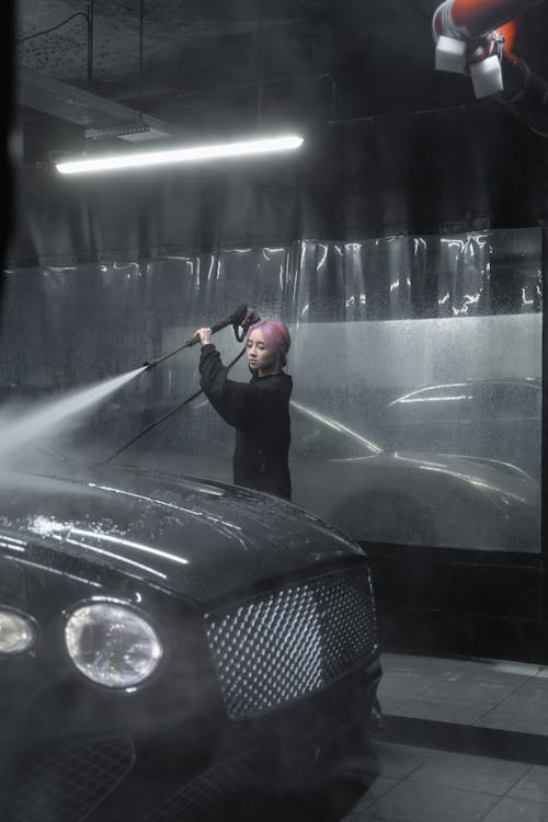 Free A Woman using Power Spray while Doing Carwash  Stock Photo