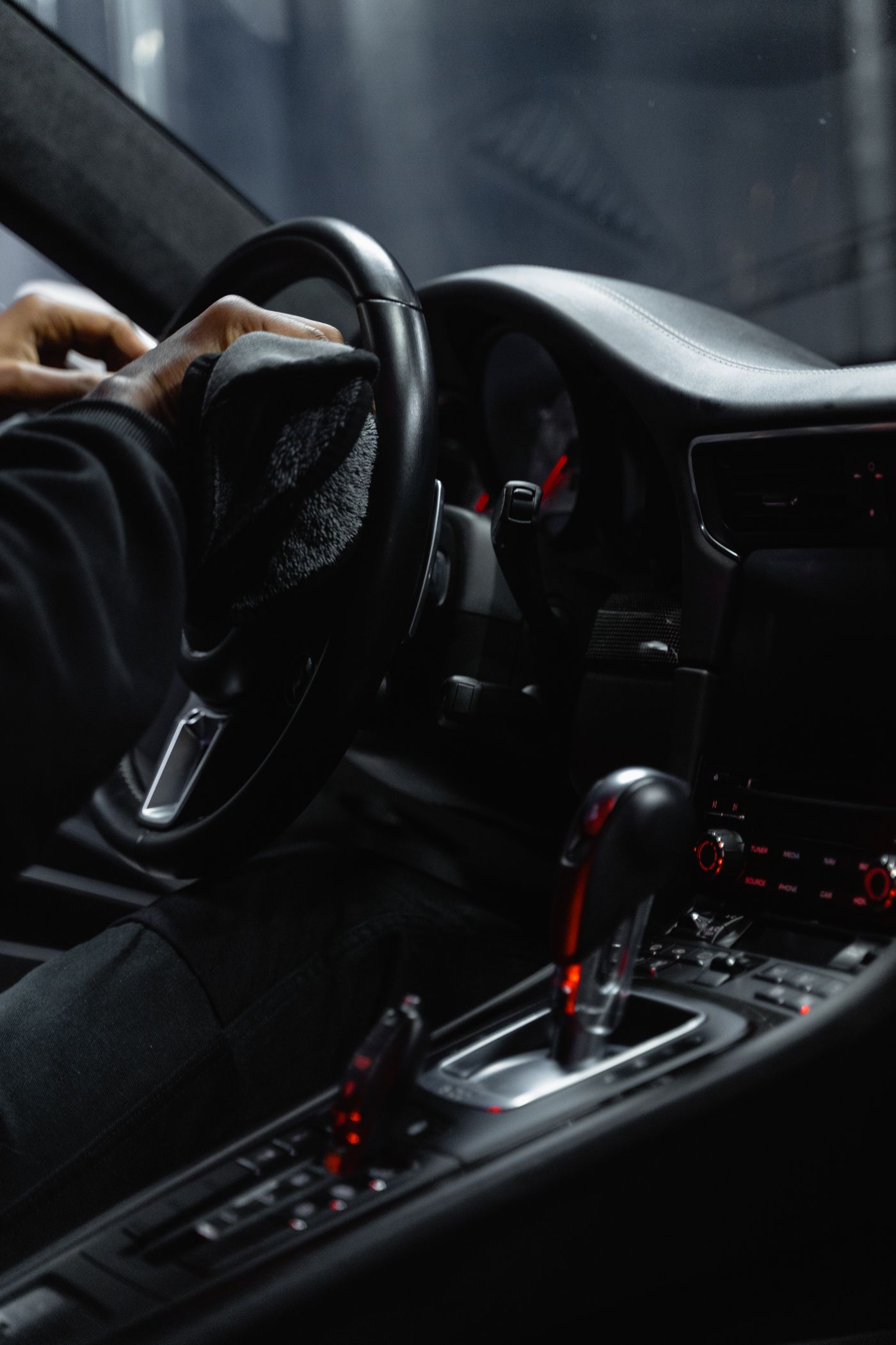 Vehicle steering wheel and dashboard being carefully cleaned