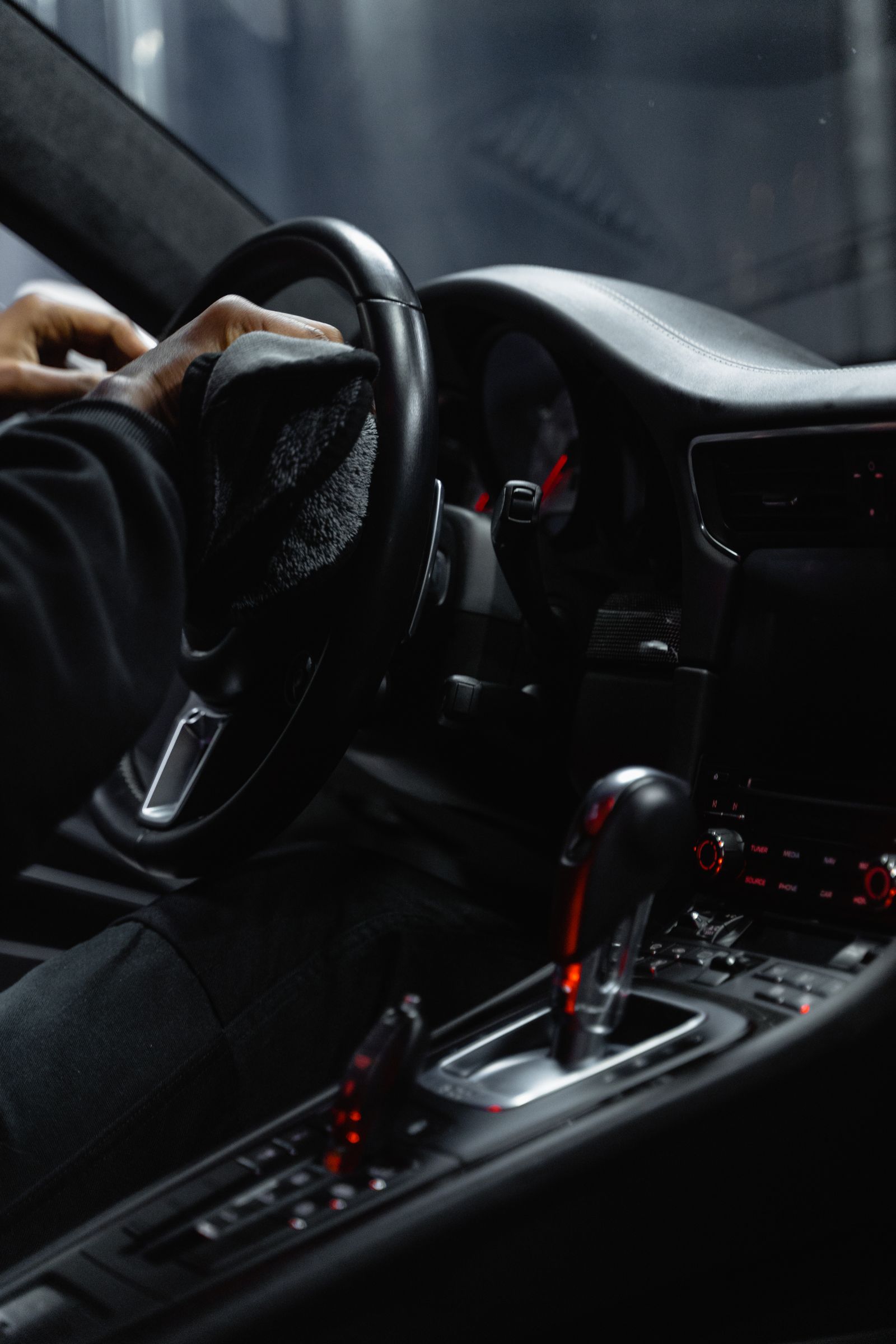 Vehicle interior being carefully cleaned around the steering wheel and dashboard