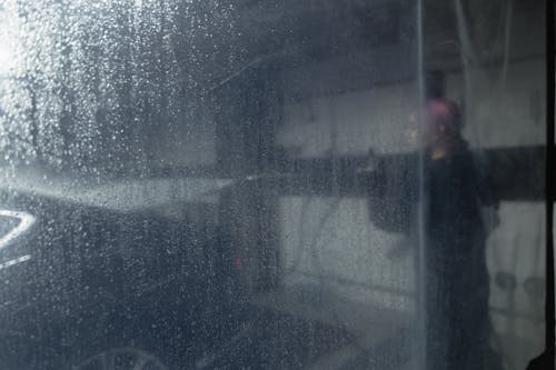 Free A Person Cleaning a Car Behind the Plastic Curtain Stock Photo
