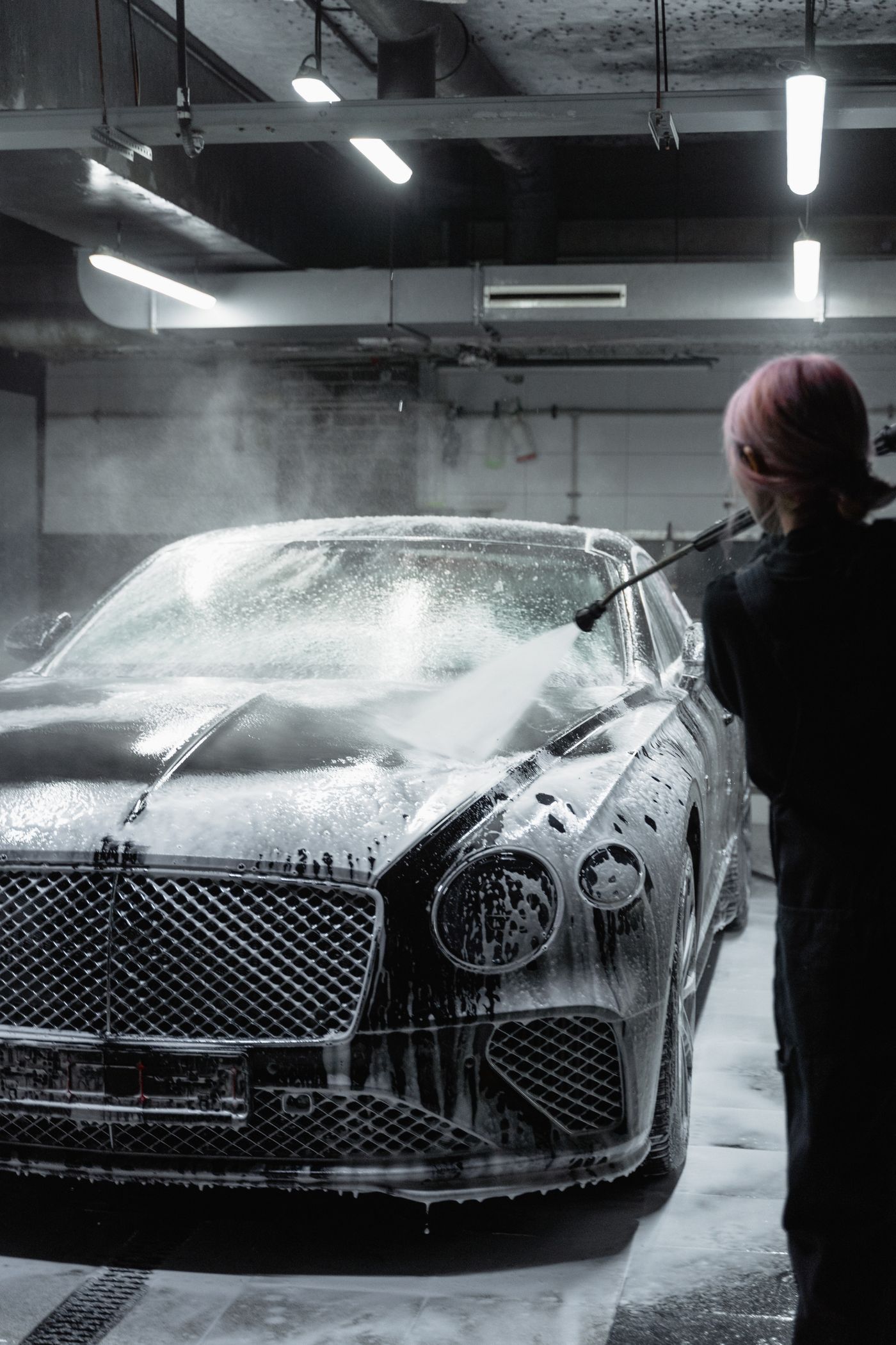 Ceramic coating being applied to a luxury car at a Houston ceramic coating studio