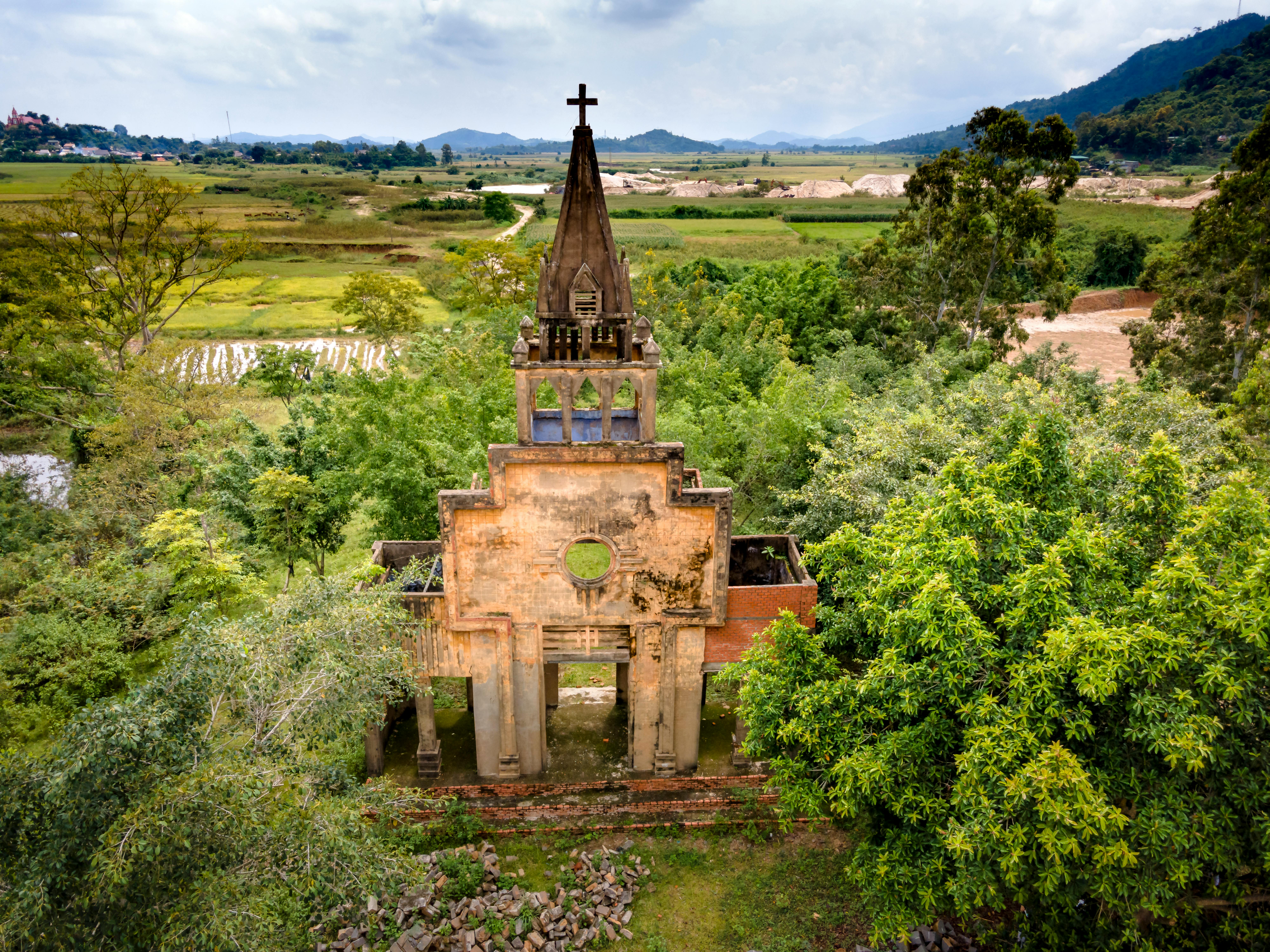 Drone shot of an abandoned chapel in the lush countryside of Vietnam.