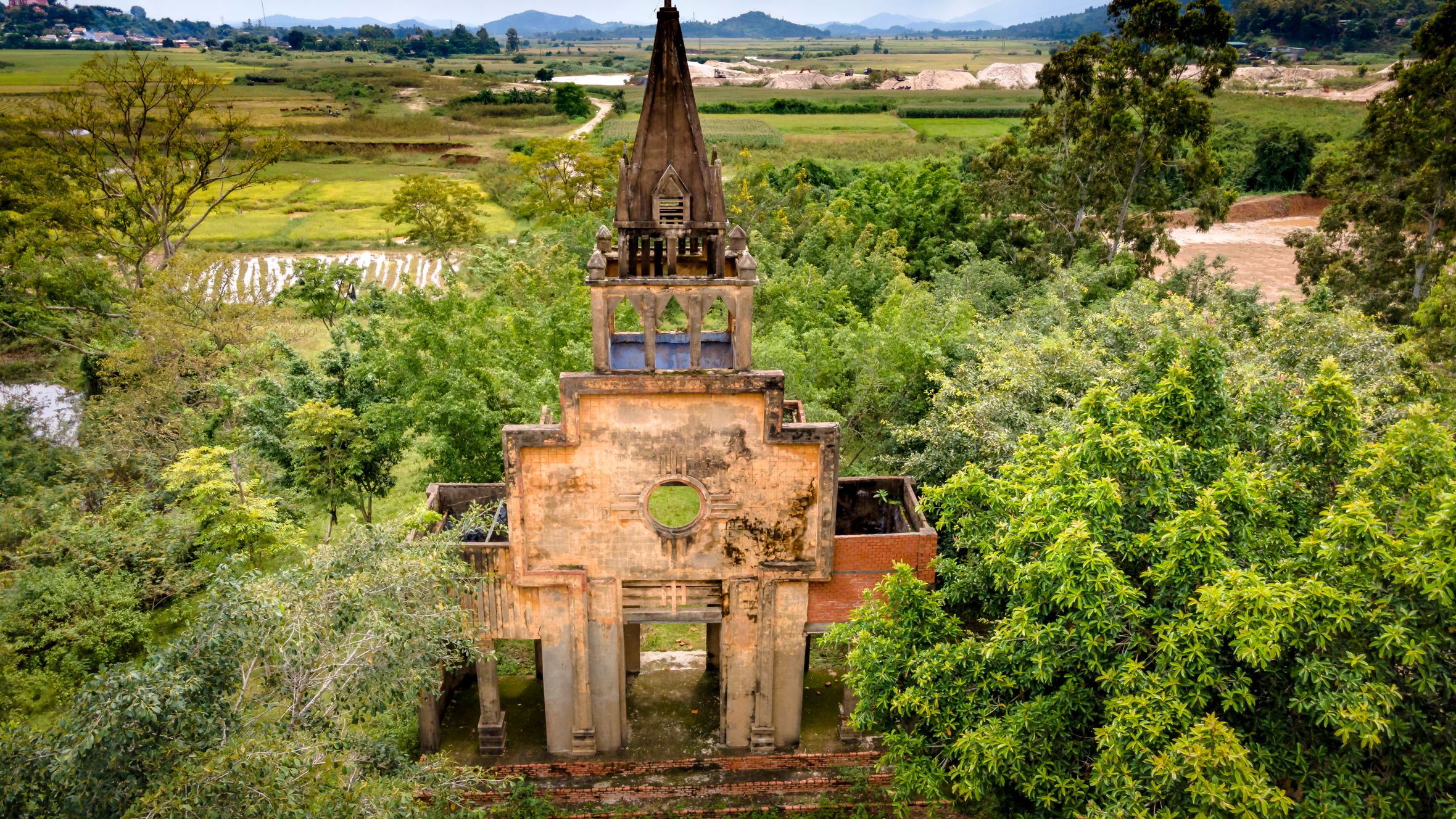Drone shot of an abandoned chapel in the lush countryside of Vietnam.